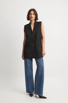 This vest features a lapel design. It has long oversize fit and shoulder pads. This vest features raw hems, a double-breasted button design, front flap pockets and a slit on the back. Styling Long Vest Outfit Ideas, Black Vest Street Style, Black Blazer Vest Outfit, Oversized Vest Outfits For Women, Long Black Vest Outfit, Black Vest Outfits For Women, Long Vest Outfits For Women, Wool Vest Outfit, Blazer Vest Outfit