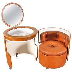 a chair with a mirror on it next to a small table and stool that has a footstool in front of it