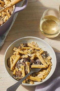 a bowl of pasta with mushrooms and wine