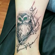 an owl with green eyes sitting on top of a tree branch and the words, she is