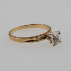 a gold ring with a white diamond on it