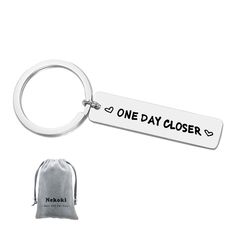 one day closer keychain with drawsack bag on the side and white background