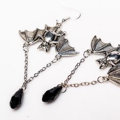 Unleash your inner darkness with these captivating Bat Earrings. Crafted from durable zinc alloy with a striking black finish, each earring measures 1.5 by 1 inch, featuring an elegant 1-inch chain adorned with a black diamond-shaped accent. Perfect for adding a touch of gothic charm to any outfit, these earrings are a must-have for your collection. Nickel-free Alloy Dangle Earrings, Nickel-free Dangle Earrings Made Of Alloy, Adjustable Alloy Drop Earrings, Punk Alloy Jewelry For Halloween, Silver Alloy Jewelry For Evening, Alloy Drop Earrings With Ear Wire, Nickel-free Alloy Earrings For Party, Nickel-free Alloy Drop Earrings, Edgy Silver Alloy Jewelry