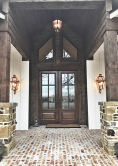 the front entrance to a house with two lights on each side and an entry door