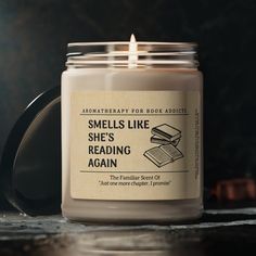 a candle that is sitting on a table with some kind of book in it's jar