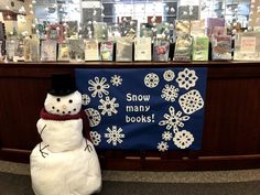 a snowman sitting in front of a book store