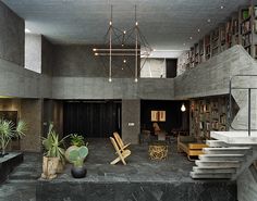 the interior of a modern house with large bookshelves and plant pots on the floor