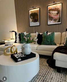 a living room filled with white furniture and lots of pillows on top of it's tables