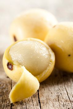 two pieces of peeled fruit sitting on top of a wooden table next to each other