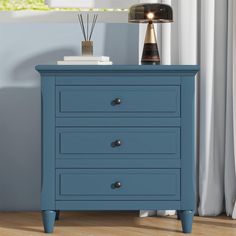 a blue chest of drawers with two lamps on top