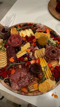 a platter filled with meats, cheeses and crackers on a table