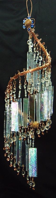 a chandelier made out of glass blocks hanging from a metal rod with beads