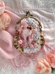 The handmade women's Vintage pink floral fabric coin purse is made of pink fabric. The pastel pink Shabby Chic coin purse is decorated with a vintage female image, vintage ruffled lace, and handmade silk roses. The handmade Shabby Chic wallet is hand-stitched to a metal frame. The handmade metal frame women's wallet has an inner white cotton lining. The vintage picture is decorated with small hand-stitched beads in a circle. This women's Vintage roses pink floral fabric handmade wallet is 17.5 c Beautiful Pink Purses, Pink Purse With Ribbons, Cheap Vintage Shoulder Bag Gift, Cheap Chic Pink Coin Purse, Chic Cheap Pink Coin Purse, Cheap Vintage Style Coin Purse For Gift, Cheap Vintage Style Coin Purse As Gift, Vintage Purses Fabric, Shabby Chic Bags