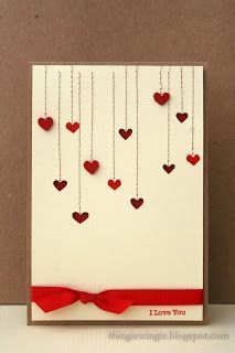 a white card with red hearts hanging from it's sides and the words i love you