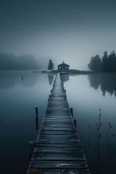 a dock that is sitting in the middle of a body of water on a foggy day