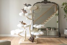 a cat sitting on top of a cloud filled tree in front of a mirror