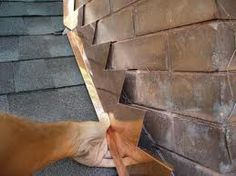 a man is working on the side of a brick wall