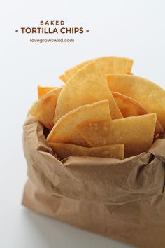 a brown paper bag filled with chips on top of a white tablecloth covered counter