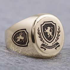 "This signet ring is crafted from 14K solid yelow gold and has a substantial feel to it with a designer quality finish. We can engrave your family crest on the top and sides of the ring and use our unique hand-crafted black finish to add contrast. We can also help you design a unique family crest using your choice of shield, symbols and text for an additional fee (please contact us for design pricing). ITEM DETAILS Item# SRGC006-FC Metal: 14K Solid Gold ITEM DIMENSIONS Width Widest Point: 18.23m Luxury Engraved Ring With Coat Of Arms For Gift, Luxury Oval 14k Stamped Signet Ring, Personalized Yellow Gold Signet Ring Collectible, Classic Personalized Signet Ring For Collectors, Luxury Oval Signet Ring, Classic Personalized Collectible Signet Ring, Luxury Oval Engraved Ring, Custom Oval Signet Ring For Formal Occasions, Luxury Oval Signet Ring With Polished Finish