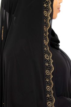 Create amazing looks with our Saba Ghashwa. This gorgeous design will enhance your abaya by giving you a striking silhouette with a hint of sparkle. Elevate your style darling and wear this beautiful ghashwa. Need some style tips? Check out our video on how to wear a ghashwa Made with luxuriously soft chiffon Long ghashwa 45" inches Delicately adorned with gold crystals Abaya not included Made in Dubai Bohemian Black Abaya With Dabka Detailing, Traditional Black V-neck Abaya, Farasha Abaya Black, Embellished Black Floor-length Abaya, Black Embroidered Floor-length Abaya, Gold Crystals, Garment Workers, Gorgeous Design, Style Tips