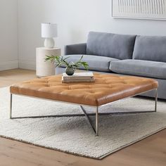 a living room with a couch, coffee table and rugs on the floor in front of it