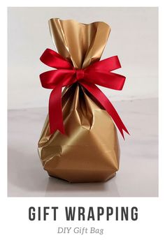 a bag with a red ribbon tied around it and the words gift wrapping diy gift bag