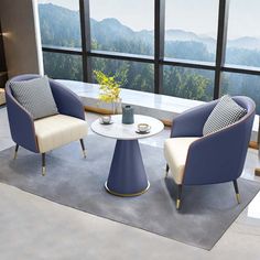 two chairs and a table in front of a large window with mountains out the side