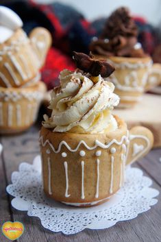 there is a cupcake with whipped cream and chocolate chips on top, sitting on a doily