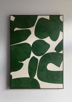 a green and white painting hanging on the wall