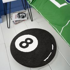 a black and white rug with the number eight on it in front of a bed