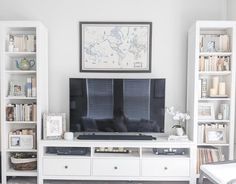 a living room filled with furniture and a flat screen tv on top of a white entertainment center