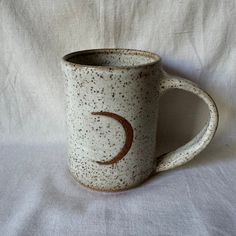 a ceramic mug with a crescent on it