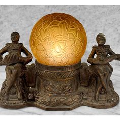 a golden egg sitting on top of a table next to two figurines