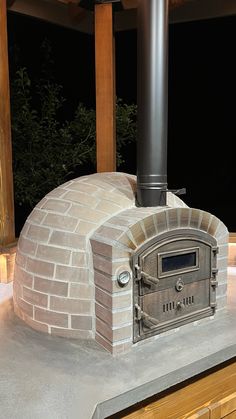 an outdoor brick pizza oven in the middle of a patio