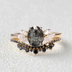 a black diamond ring with white and yellow diamonds on it's sides, set in gold