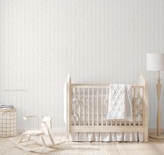 a baby's room with a white crib, rocking chair and wallpaper