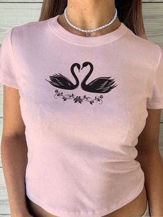 "🌟 Thank you for stopping by GirlyThreadsCo! This swan baby tee is made to order just for you! This is the perfect baby tee for ballet dancers, coquette lovers, trendy girlycore fans, or is great for everyday wear! 👕 PRODUCT & DESCRIPTION 🛑 PLEASE NOTE: The sizing of this t-shirt is not the same as standard US Women's sizes. We recommend you size up 1-2 sizes to achieve the same fitted look as our model photo. This shirt does run small around the arms, shoulder, and bust area and we recommend sizing up. Our Gildan 5000B t-shirts are pure comfort and 100% cotton. Please be sure to check the sizing chart to choose the right size for your preferred fit. Lay your favorite baby tee at home flat and measure armpit to armpit to compare to the size chart in the photos. Also keep in mind that th Coquette T Shirt, Coquette Shirts, Clothing Coquette, Coquette Clothes, Coquette Clothing, Coquette Top, Dollette Coquette, Coquette Shirt, Shirt Coquette