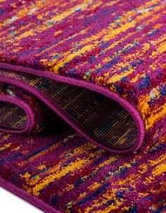 the purple and yellow rug is folded up