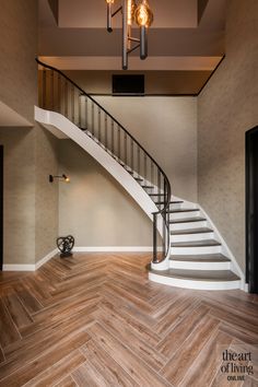 an empty room with wooden floors and a staircase leading up to the second floor,