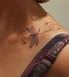 a woman's chest with a dragon tattoo on her left shoulder and the word love written in cursive writing