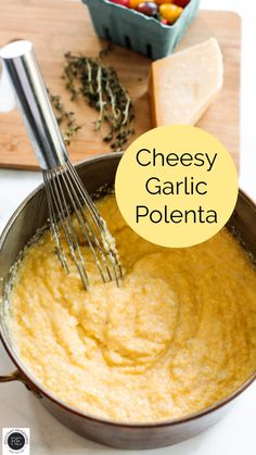 cheesey garlic polenta in a pan with a whisk on the side