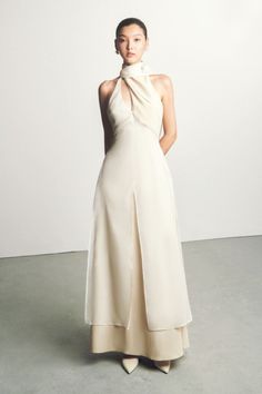 This season, make your entrance in this Yen layered high neck floss silk ankle length dress. Crafted with a 3D draped high neckline and a gorgeous wrapped scarf detail, the look is contemporary, chic, and elegant, perfect for any special occasion. Nude Wedding Guest Dress, Luxury Nude Sleeveless Maxi Dress, Luxury Nude Maxi Dress, Billionaire Fashion, Luxury Asymmetrical Chic Slip Dress, Luxury Long Cheongsam For Women, High-end Elegant Embroidered Linen Dress, Pastel Dresses, Mean Blvd