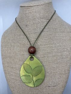 This is a 2 x 1.5 inch lightweight Pendant made with Green Premo polymer clay. Leaf pressed by hand using mica powder to shine. It has 16 inch waxed leather cord, lobster claw clasp, and wooden bead. Green Hand Painted Artisan Necklace, Artisan Green Hand Painted Necklaces, Artisan Hand Painted Green Necklace, Artisan Green Hand Painted Necklace, Green Hand Tooled Jewelry For Gift, Adjustable Hand Painted Nature-inspired Jewelry, Adjustable Green Necklace With Waxed Cord, Adjustable Green Waxed Cord Necklace, Adjustable Green Necklace For Everyday Use