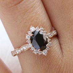 a woman's hand with a black and white diamond ring on top of her finger