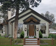 a small house with a wooden fence around the front door and steps leading up to it