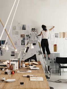 a woman standing on a ladder in an office