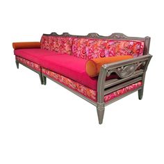 a pink and orange couch sitting on top of a white floor