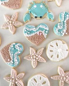 decorated cookies are arranged in the shape of hearts, seashells and starfish