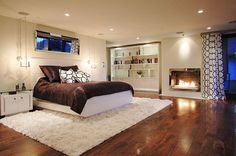 a large bed sitting in the middle of a living room next to a fire place