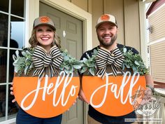 two people are holding signs that say hello fall